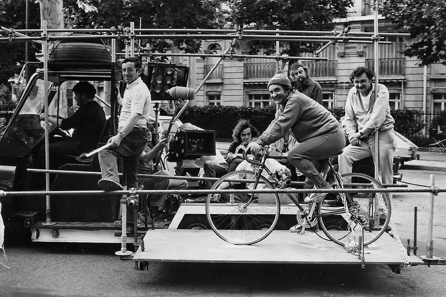 Jean Carmet sur son vélo en Cadillac Travelling, conduite par Bernard Chateau